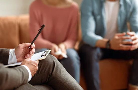 erapeuta profesional brindando orientación a una pareja durante una sesión presencial