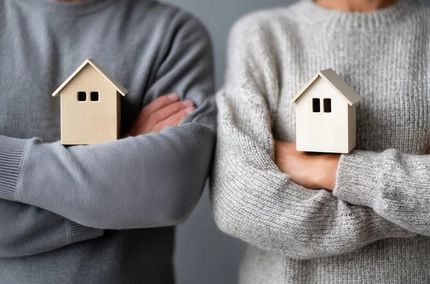 Pareja sosteniendo cada uno una casa en sus brazos, simbolizando manejo de separación temporal.